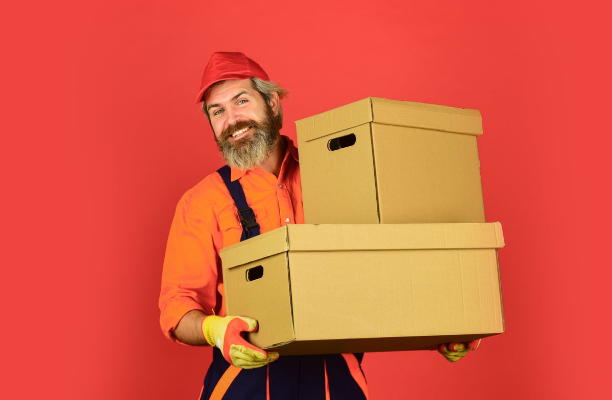 Life Just Got Better. purchase of new habitation or repair of room. Man wearing boilersuit packing boxes. move to new apartment. bearded loader in uniform. Cardboard boxes - moving to a new house